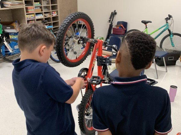 two boys working on bike chain