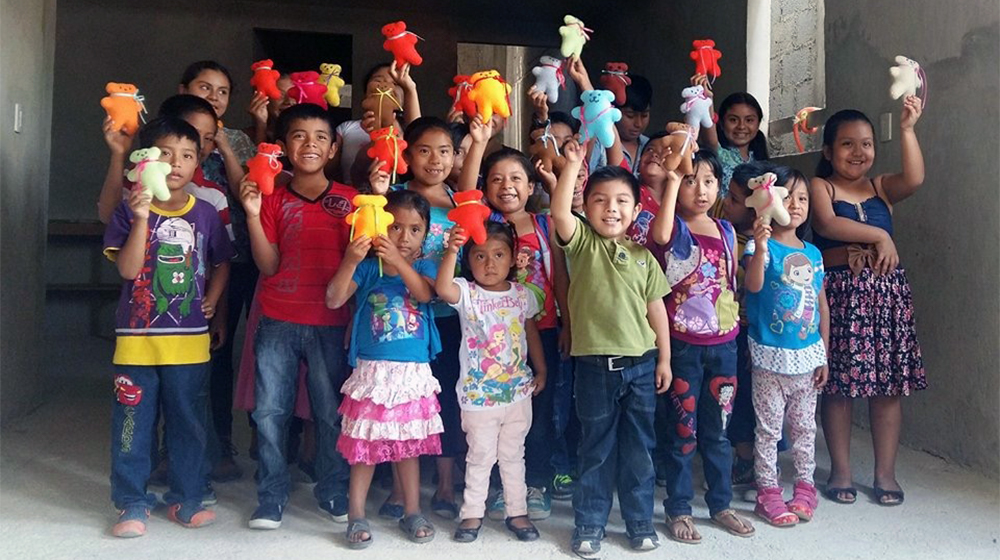 Children from Mexico show off their creations from the "Sew Much Love" club. 